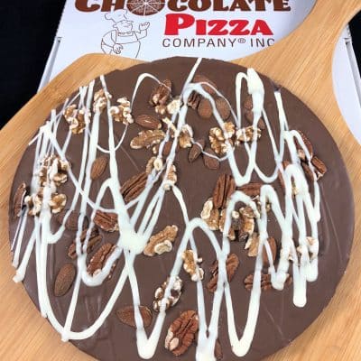 Chocolate Pizza topped with pecans almonds walnuts in a pizza box
