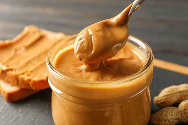 A spoon full of creamy peanut butter